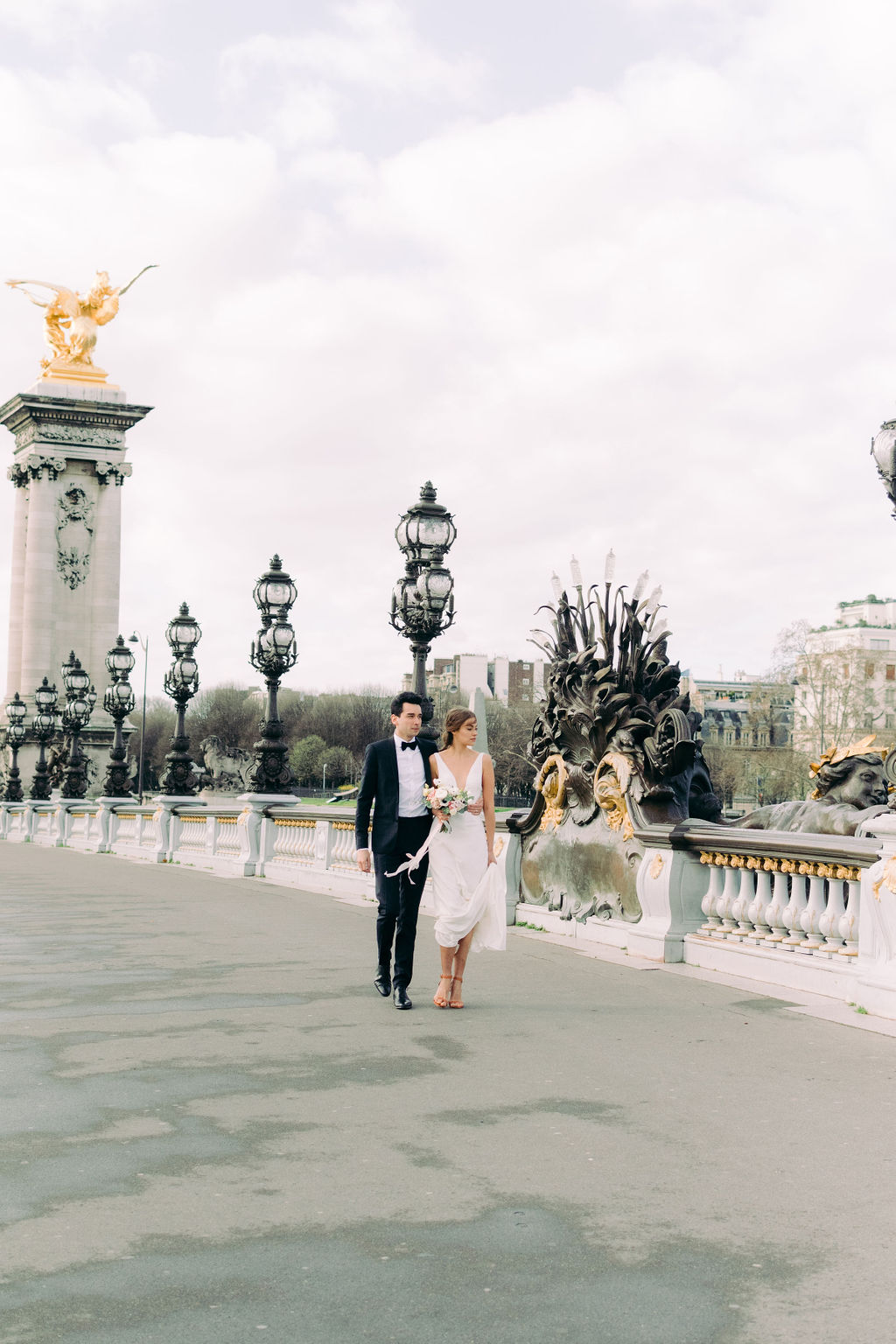 des mariés marchent sur pont alexandre III à Paris